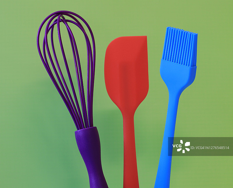 绿色背景下的彩色硅胶烘焙工具图片素材