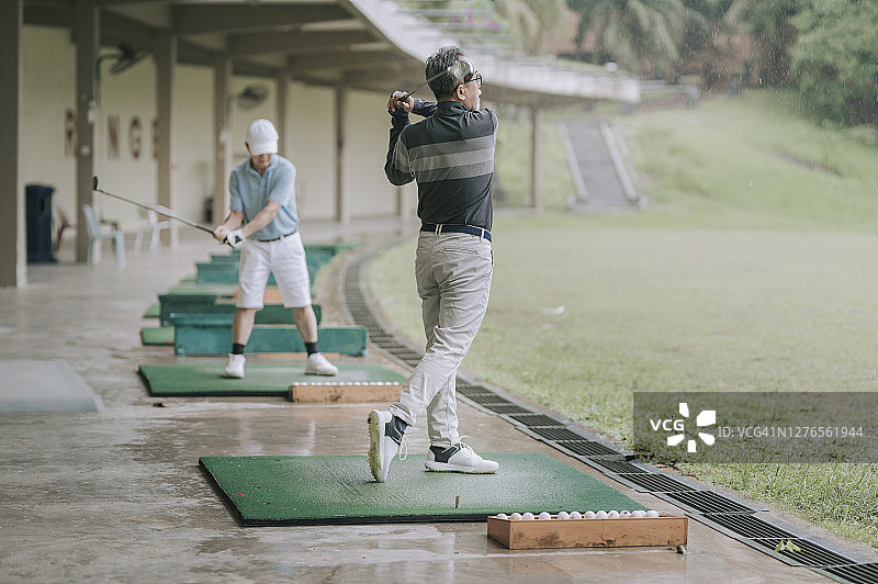 在练习场挥杆的高尔夫球手图片素材