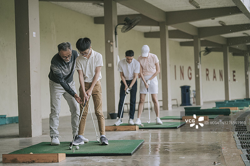 中国老人教孙子在高尔夫练习场打高尔夫图片素材