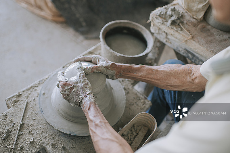 亚洲华裔老年陶艺师在工作室工作图片素材