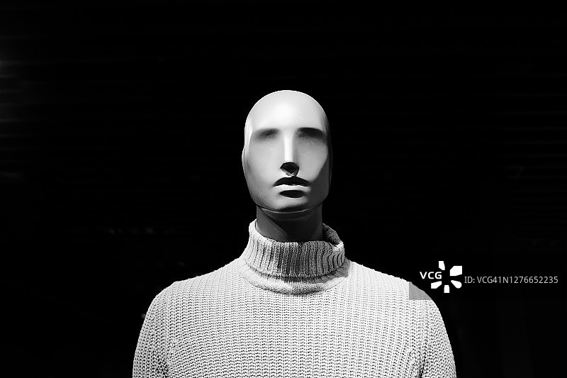 昂贵针织羊绒经典毛衣中的无脸人体模型，背景是闪烁的灯光图片素材