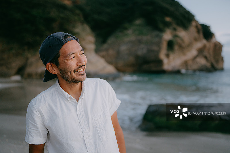 黄昏时分在海滩上的日本男子肖像图片素材