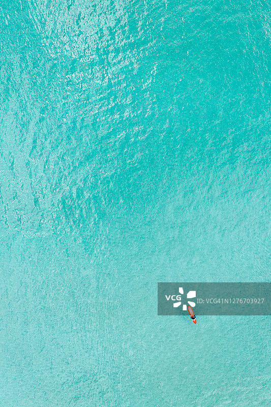 鸟瞰冲浪者在清澈的蓝色的水图片素材