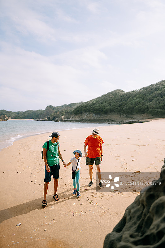 三代同堂家庭在日本海滩上散步图片素材