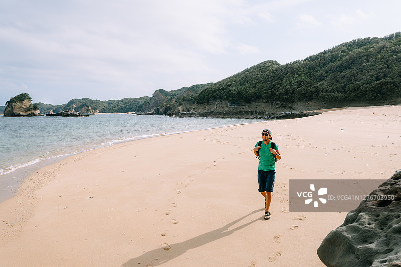 男人走在僻静的海滩上，日本图片素材