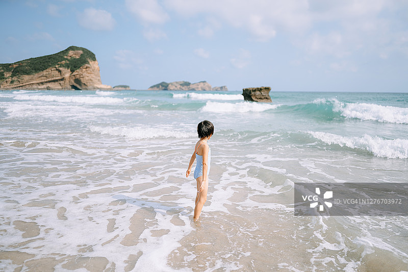 在海滩上与海浪玩耍的年轻女孩图片素材