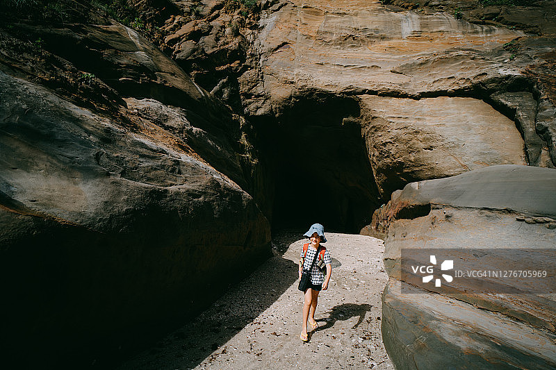 年轻女孩走出洞穴，对着镜头微笑图片素材