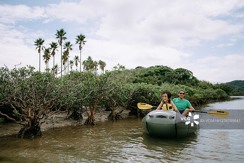 父亲带女儿在河上划橡皮艇图片素材