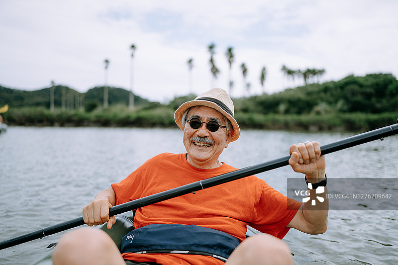 划皮划艇穿过河流的年长日本男人图片素材