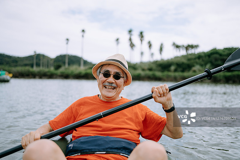 划皮划艇穿过河流的年长日本男人图片素材