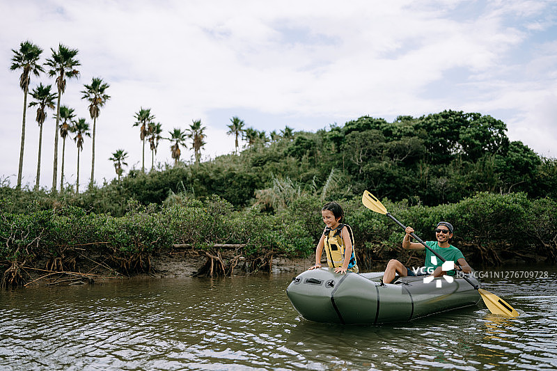 父亲带女儿在河上划橡皮艇图片素材
