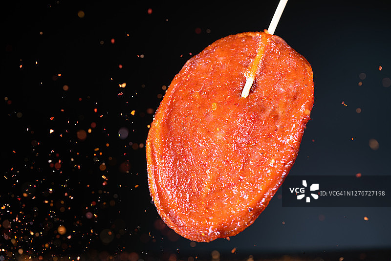 大块火腿肠与红色辣椒在空中高速飞舞图片素材