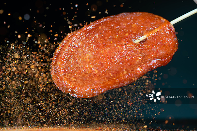 大块火腿肠与红色辣椒在空中高速飞舞图片素材