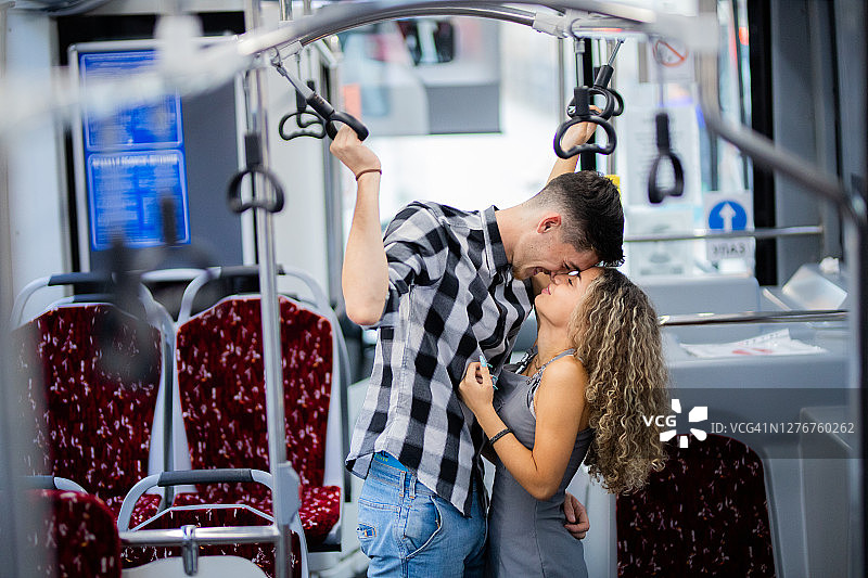 年轻夫妇在公共汽车上亲吻图片素材