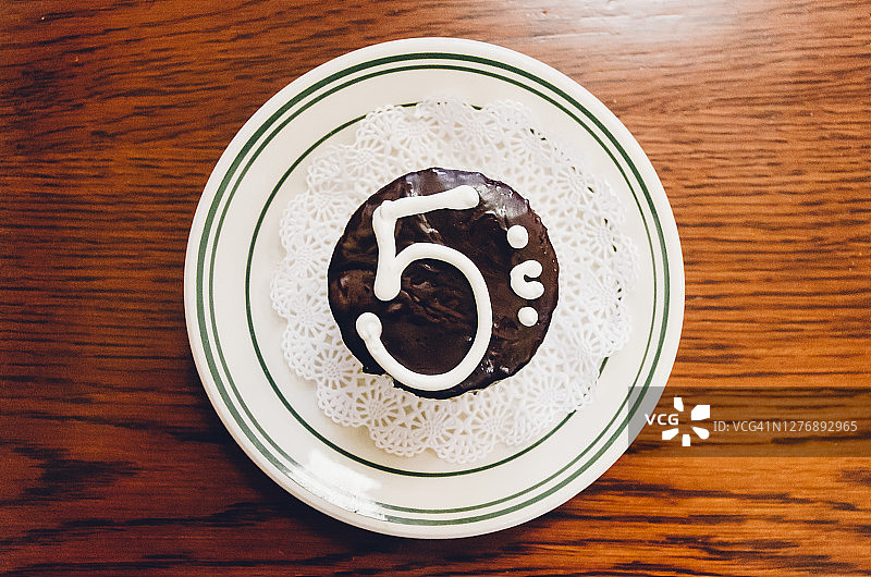 五分镍币巧克力纸杯蛋糕，在木桌上的复古盘子上供应图片素材