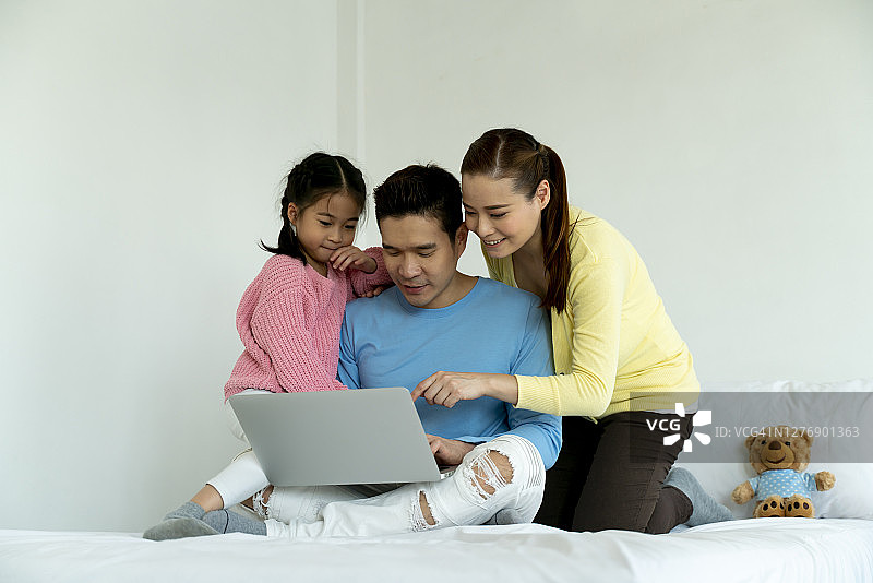 亚洲家庭在床上看平板电脑 портрет，周末休闲教育图片素材