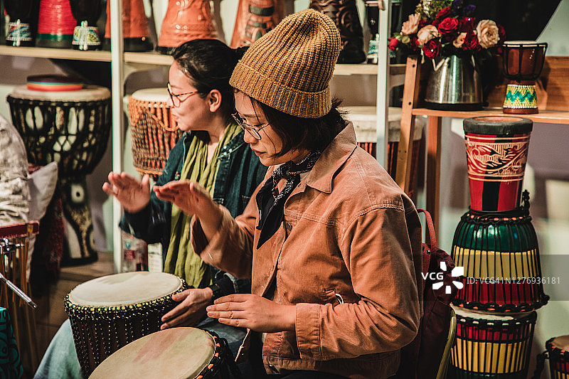 两位亚洲女性一起演奏邦戈鼓图片素材