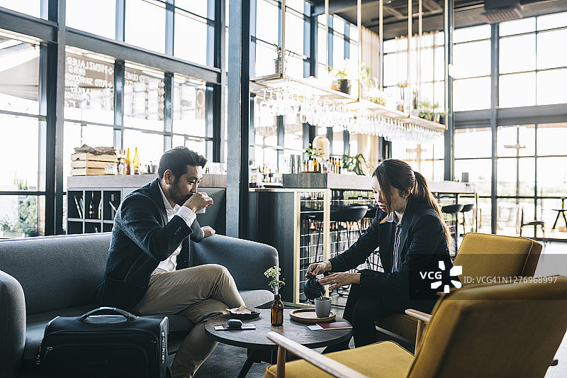 在机场航站楼出发前喝咖啡和茶的乘客图片素材