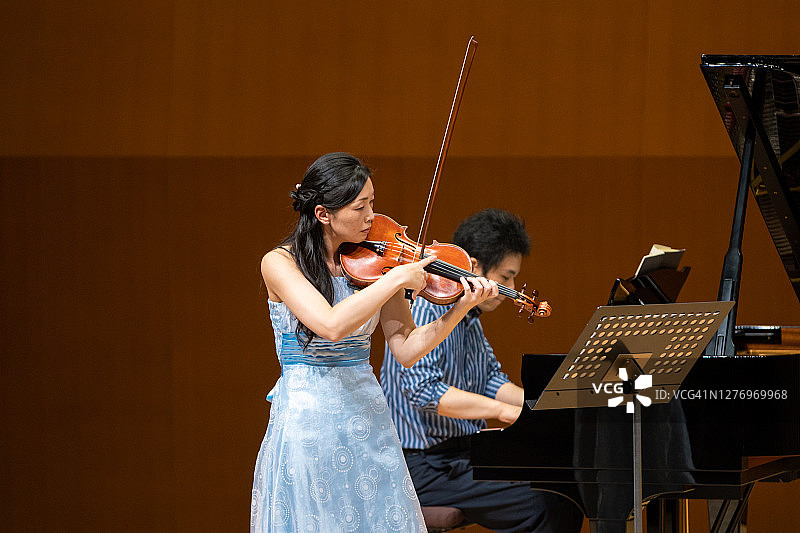 女小提琴手与钢琴家在音乐厅演奏小提琴图片素材
