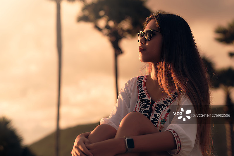 观看日落的年轻亚洲女性肖像图片素材