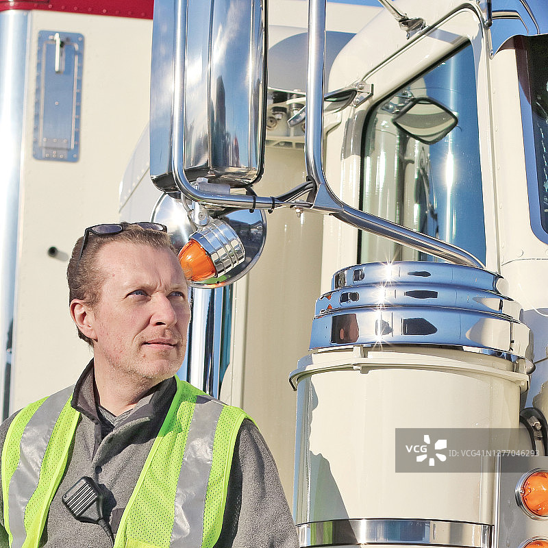 卡车司机站在半挂卡车前方图片素材