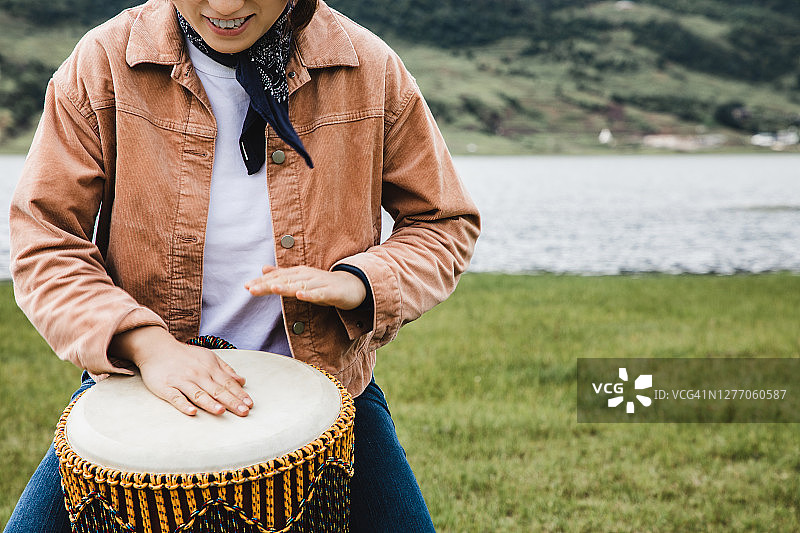 亚洲女性在野外户外演奏邦戈鼓图片素材