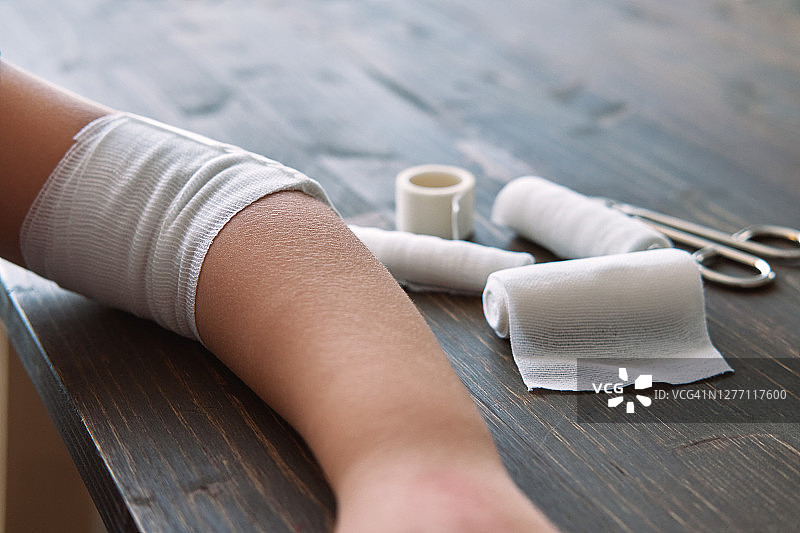 儿童手臂缠绕绷带接受急救图片素材