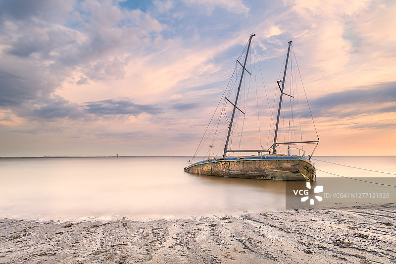 日落时搁浅游艇的长曝光照片图片素材