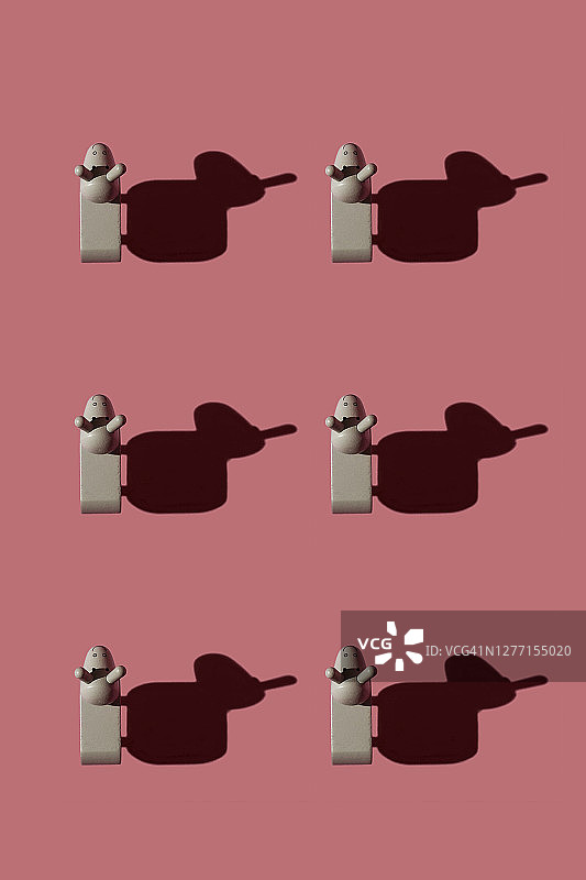 粉红色背景上的棕色小驴雕像图案图片素材