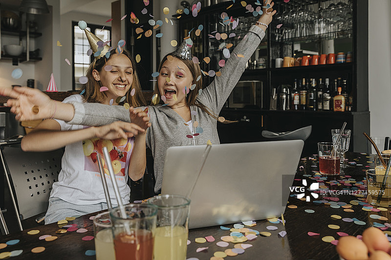 快乐的朋友们在家中参加生日派对时，通过笔记本电脑进行视频会议。图片素材