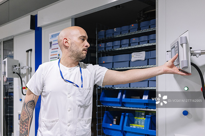 秃头男药剂师在医院储藏室使用电脑图片素材