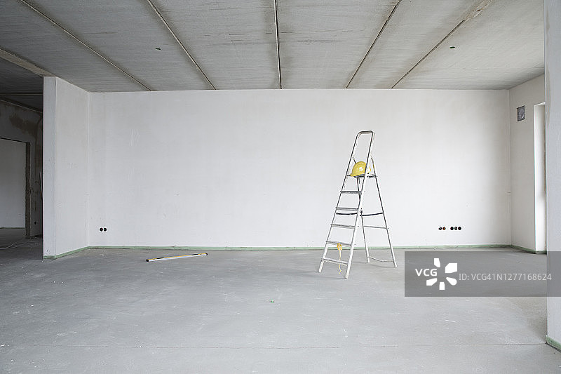 装修房屋中靠墙放置的安全帽和梯子图片素材