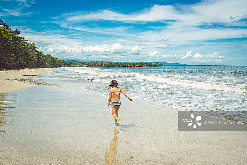 在美丽的热带海滩上奔跑的孩子图片素材