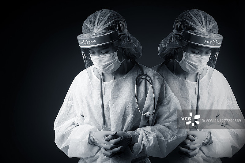 戴防护面罩和PPE套装的亚洲女医生，抗击新冠病毒疫情图片素材