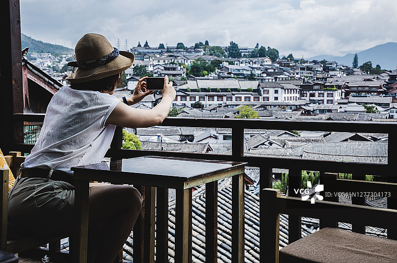 用相机拍摄老城区景色的亚洲女人图片素材