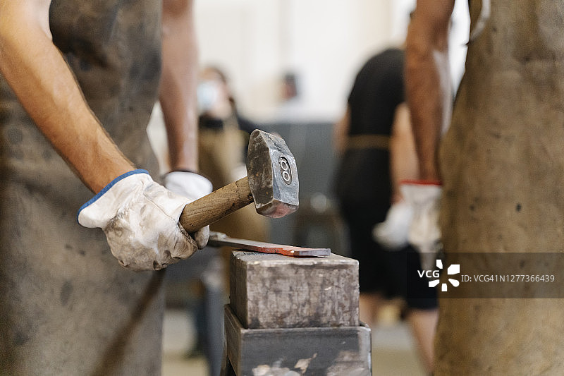 铁匠用锤子锻造热金属图片素材