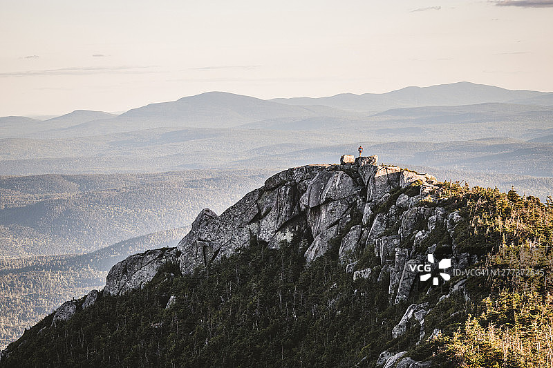 孤独的徒步旅行者站在缅因州巴克斯特州立公园的岩石顶峰图片素材