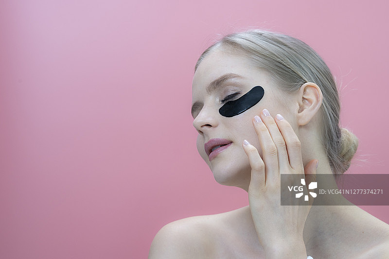 使用美容产品医用眼贴的美丽女人肖像图片素材
