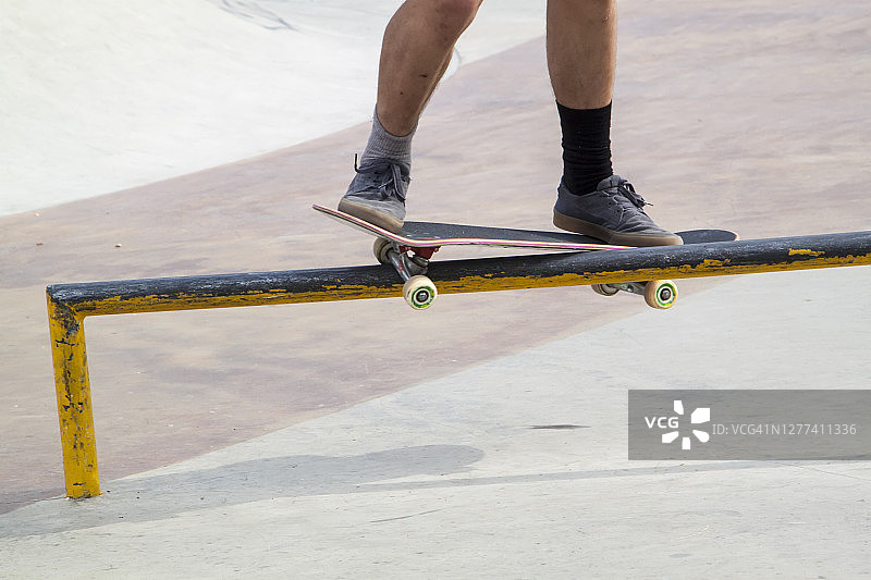 滑板公园里，滑板手沿着金属坡道的边缘滑行图片素材