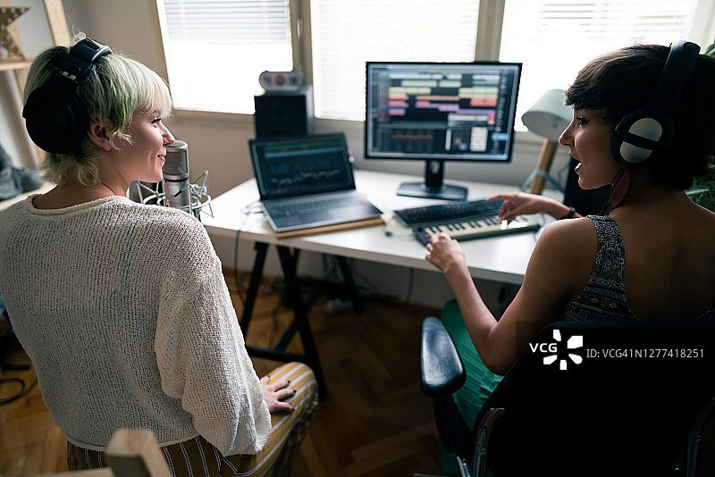 在音乐工作室里讨论新歌的两名女音乐人图片素材