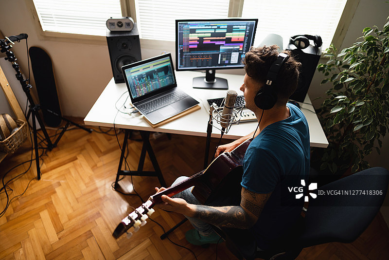 在音乐工作室弹吉他唱歌的白人音乐家图片素材