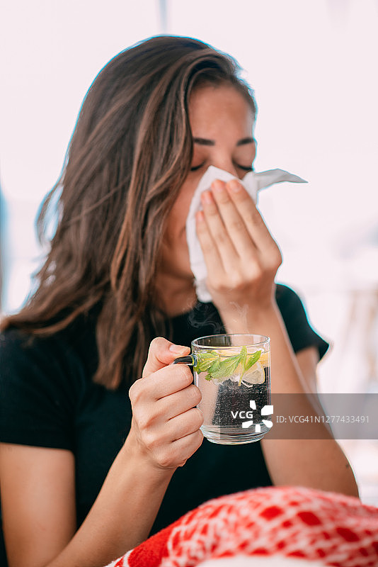 生病的女人在喝草药茶图片素材