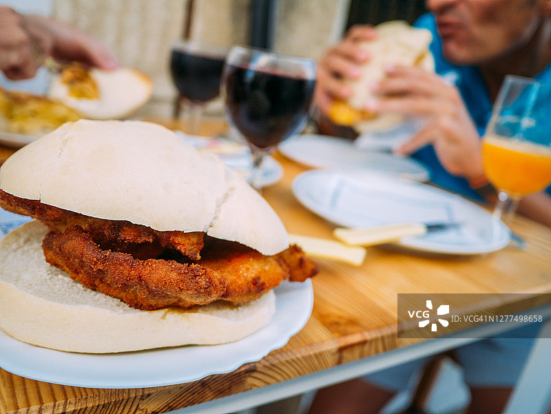 炸猪里脊三明治和用餐的人们图片素材