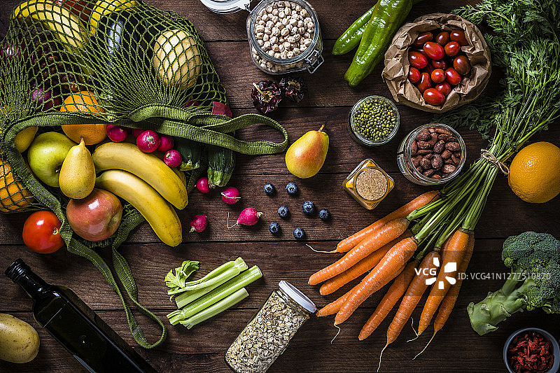 可重复使用的购物袋，周围环绕着纯素食配料、可回收罐子和纸袋图片素材