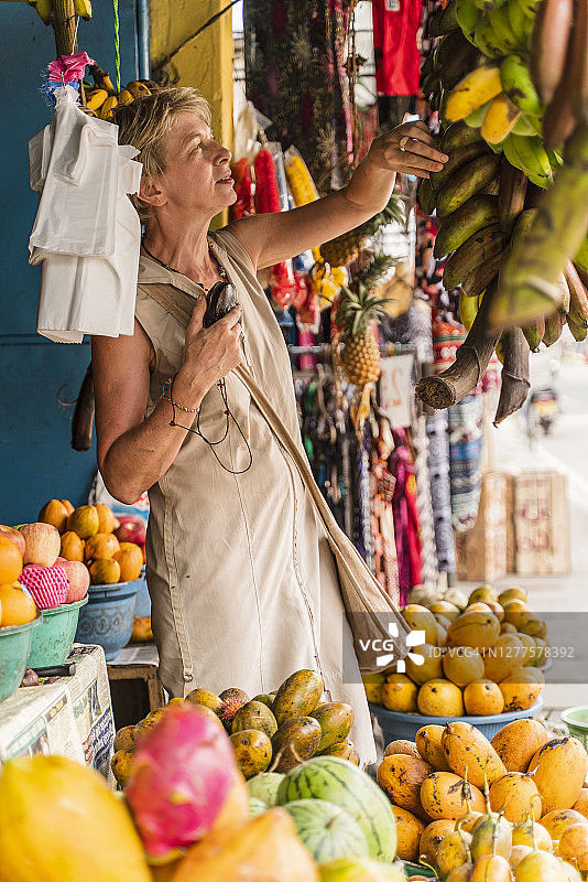 斯里兰卡阿卢特加马街头食品市场购物的50岁活跃欧洲老年妇女图片素材