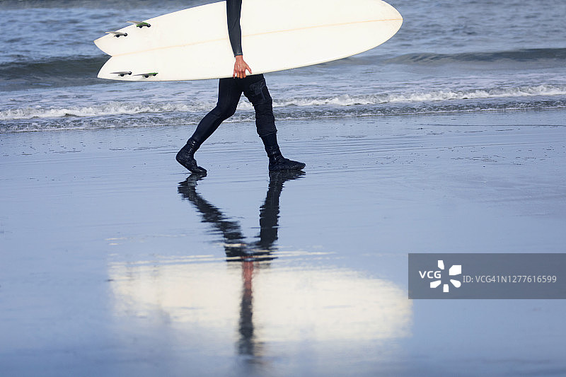 男子携带冲浪板行走图片素材