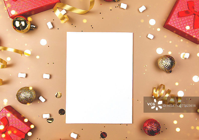 圣诞或新年贺卡空白纸，礼品盒和节日装饰品金色背景俯视图图片素材