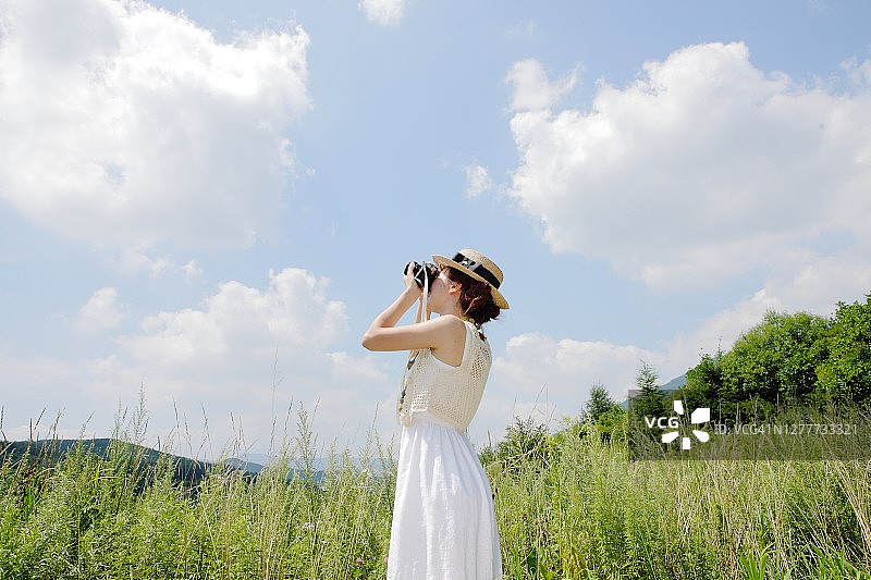 年轻女人拿着相机拍照图片素材
