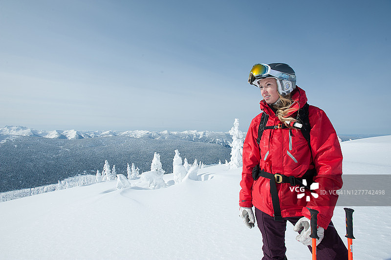 在高山斜坡上休息并向外看的年轻女子图片素材