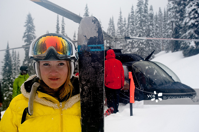在滑雪坡上直升机外的女子越野滑雪者肖像图片素材